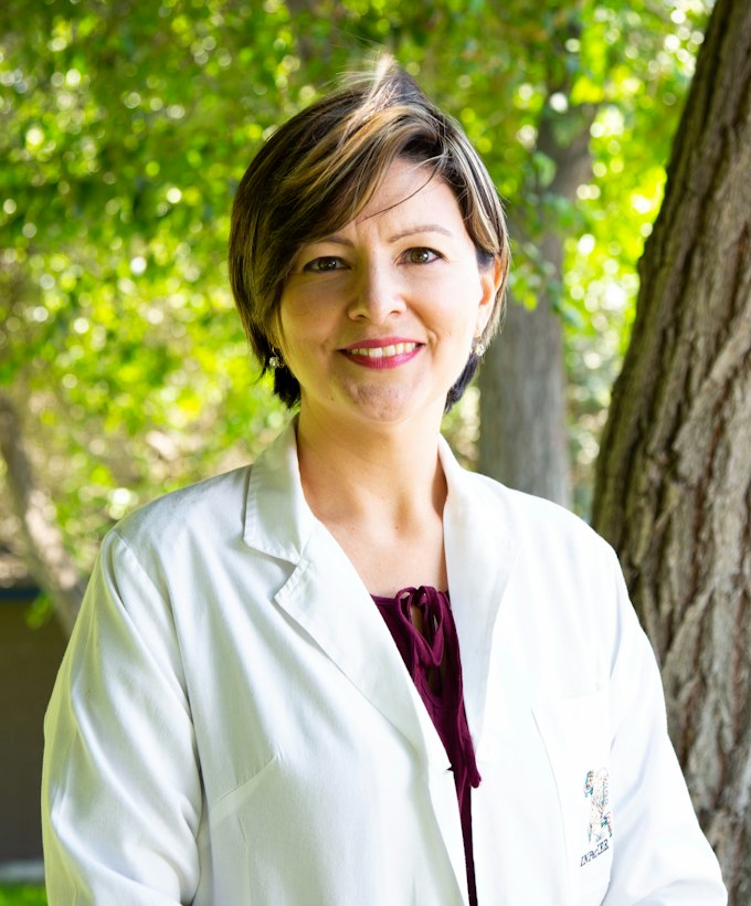 Retrato de la doctora Renata Iturbe, con bata blanca, al aire libre