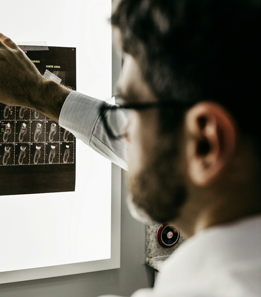 Odontólogo revisando una serie de radiografías dentales en un negatoscopio